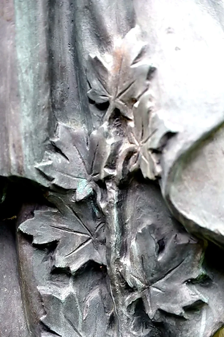Detail of a branch of maple leaves sculpted in bronze