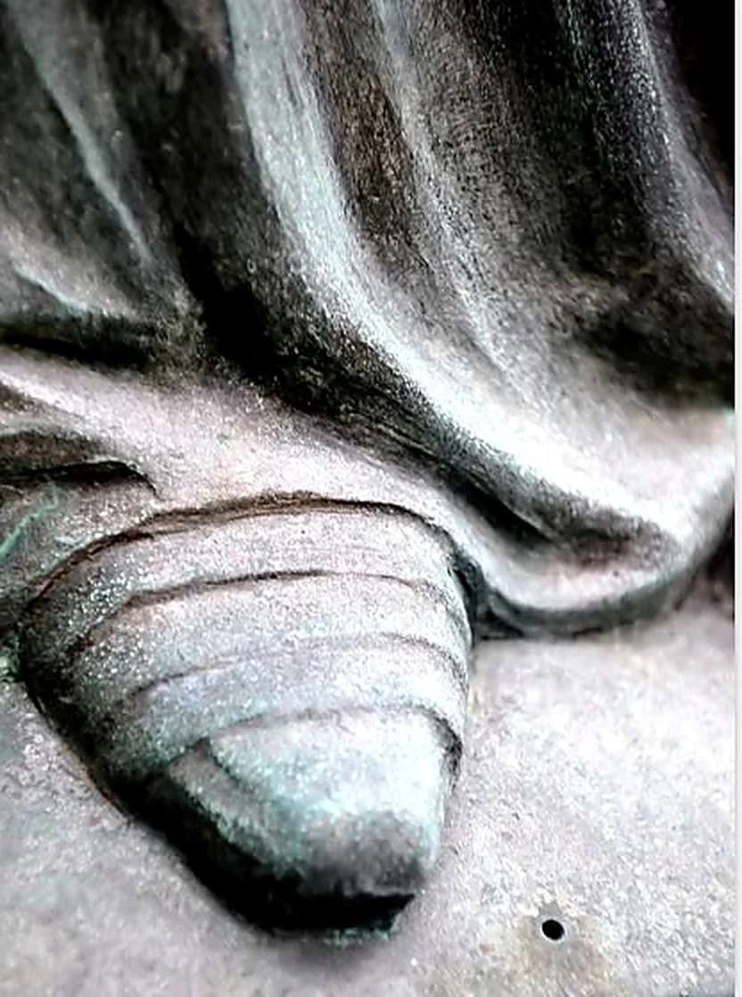 Détail d’un pied de la statue sous le drapé